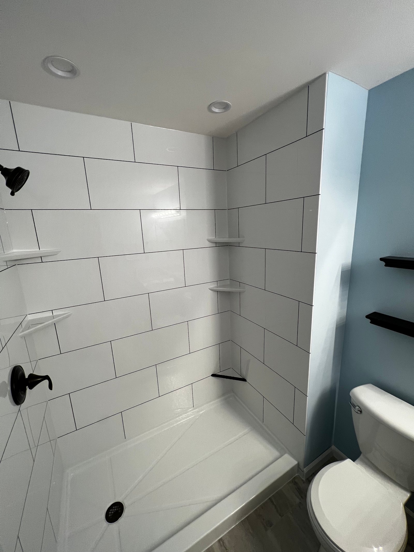 Tub and shower with gray marbled walls and chrome fixtures in Wisconsin